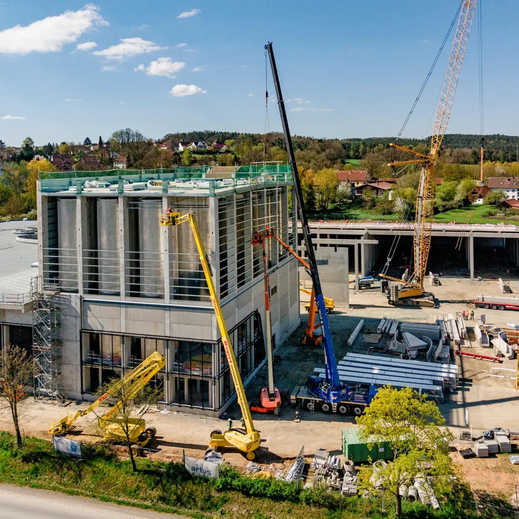 Luftaufnahme der Baustelle der Brauerei Maisel in Bayreuth mit Stahlhallenbau und Kränen.
