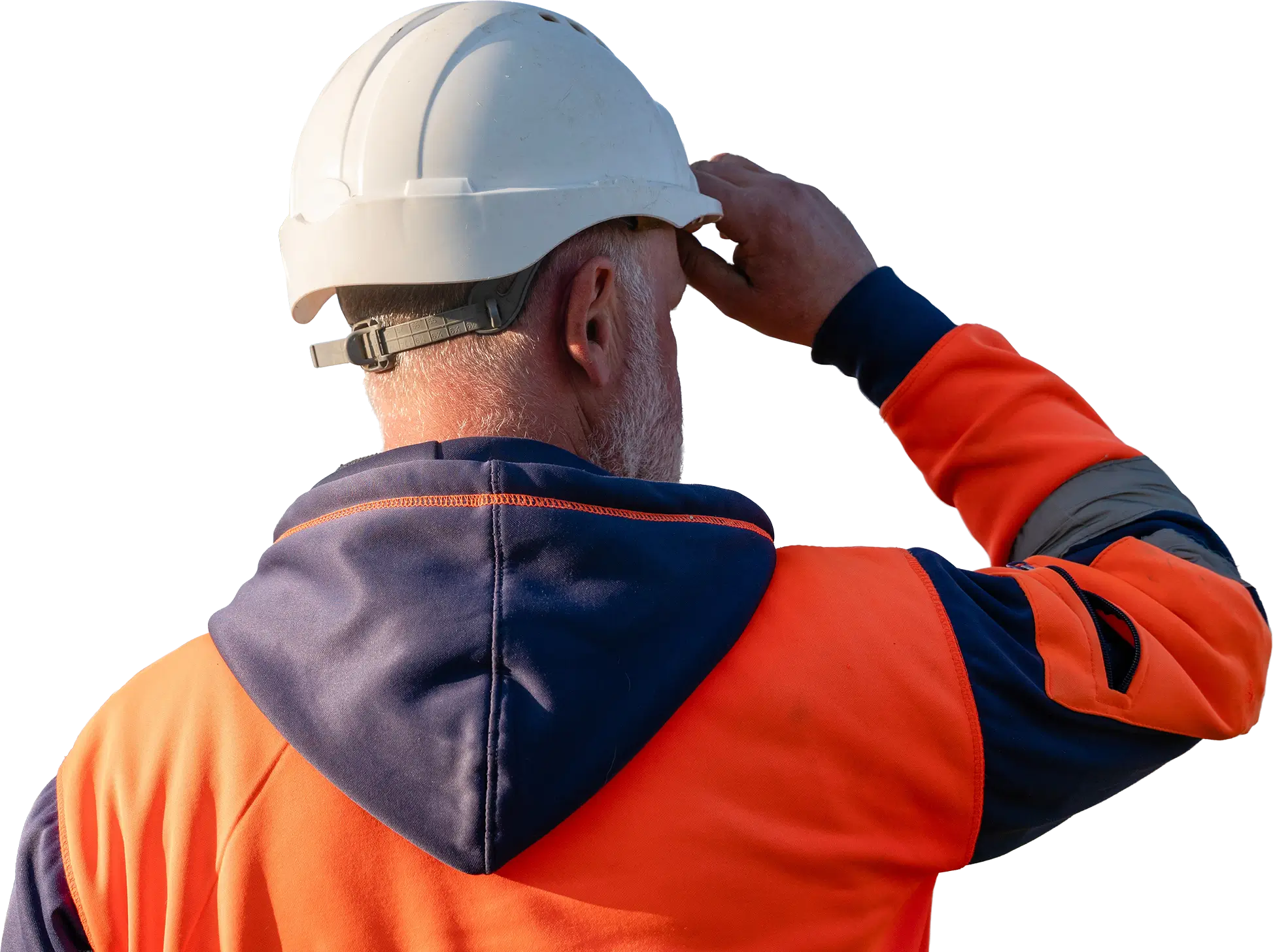 Mitarbeiter mit Helm blickt über eine Baustelle.
